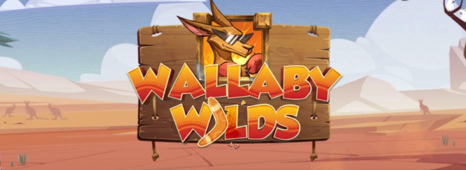 Illustration of a wallaby wearing sunglasses and a scarf, framed on a wooden signboard. The text 'Wallaby Wilds' appears in bold red and yellow lettering, with a boomerang design on the word 'Wilds.' The background shows a desert landscape.